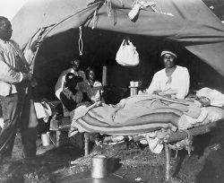 1927 photo African Americans in front of tent, with one man sitting up 