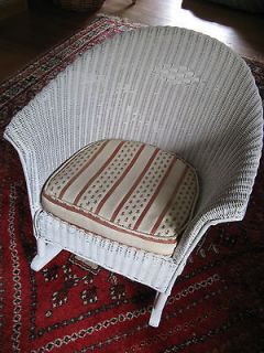 Antique childs white wicker rocker with cream and red stripe cushion
