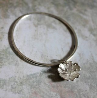 Handmade Sterling silver charm bangle. A sterling silver flower 