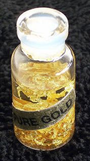 pure gold flakes in a small glass vial filled with
