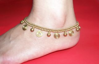 Superbly handcrafted using brass beads , spirals and bells .