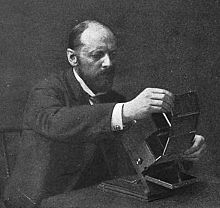 Frederic E. Ives inserting a Kromogram into a Junior Kromskop, circa