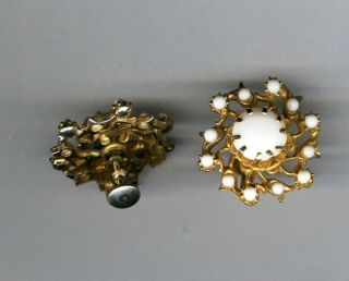White plastic and gold colored metal twist clip earrings.